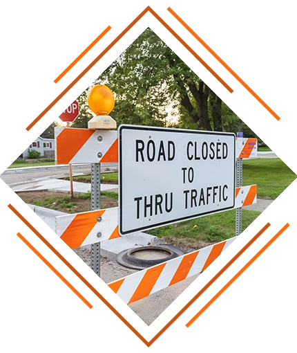 stylized close-up photo of a lane closure sign: "Road Closed to Thru Traffic" (KSK traffic control services decorative image)